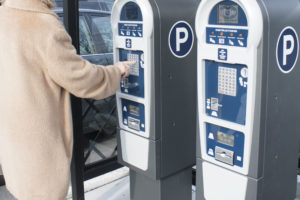 Jean Hanson, a Bronxville resident, uses the new parking kiosks in the Garden Avenue lot. She pays with coins, but the machines also accept dollar bills and credit cards. Photo/Corey Stockton
