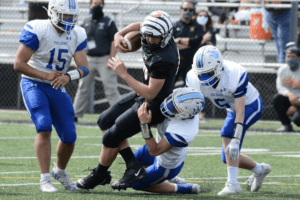 John Benke is dragged down by Haldane defenders on April 24. Benke’s game-saving catch and run in the fourth quarter set up a Jason Santos field goal. Photo/Mike Smith
