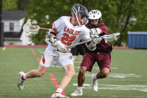 Owen Blume rushes past a Harrison defender during a game on May 5, 2022. Blume scored Eastchester's final three goals to lead his team to an 11-10 come-from-behind victory.