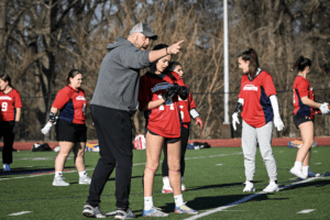 Eastchester varsity girls flag football head coach Vito DeBellis instructs his players during a March 16 practice. Eastchester is  one of several Section 1 schools that have started flag football programs this spring.